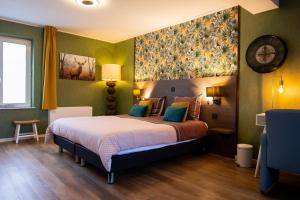 a bedroom with a bed with a large painting on the wall at Hotel De Klok in Zutendaal