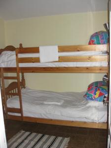 a bedroom with two bunk beds with white sheets at Casa nel bosco alle Macinaie in Monte Amiata