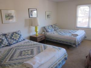 a bedroom with two beds and a table with a lamp at Dodgeton Creek Inn in Cuchara