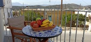 a basket of fruit on a table on a balcony at Andrea's House in Kavoúsion