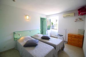 two beds in a room with two pillows on them at Auberge de la Couronne in Lablachère