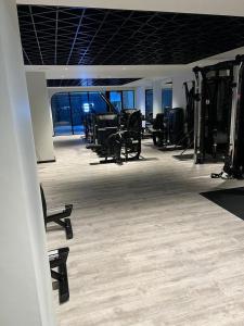 a room with a gym with chairs and machines at Luxury Townhouse In Central Manchester in Manchester