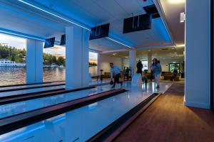 a swimming pool in a building with people walking around at Hotel Robert's Port in Mikołajki