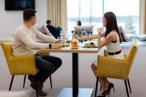 Hotel Robert's Port في ميكووايكي: يجلس رجل وامرأة على طاولة في مطعم