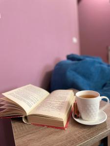 um livro aberto e uma chávena de café numa mesa em The Nest JERMUK em Jermuk