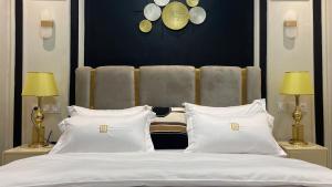 una camera da letto con un grande letto con cuscini bianchi di Suna' a Home Bonapriso a Douala