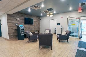 - une salle d'attente avec des chaises et un téléphone payant dans l'établissement Candlewood Suites Merrillville, an IHG Hotel, à Merrillville