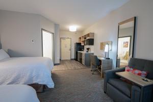 a hotel room with a bed and a couch and a desk at Candlewood Suites Merrillville, an IHG Hotel in Merrillville