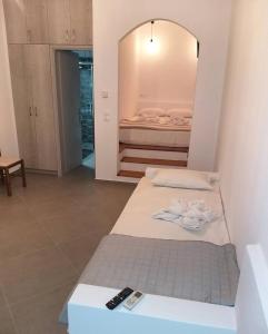 twee bedden in een kamer met een spiegel en twee afstandsbedieningen bij Mavrikou Helen Apartments in Skiros