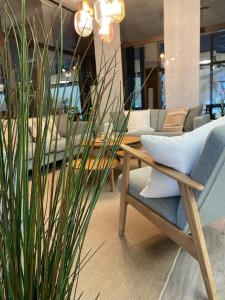 a chair and a table and a plant in a room at Aquantis Bensersiel in Bensersiel