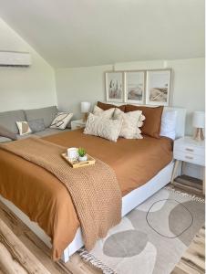 um quarto com uma cama grande e um sofá em Modern Coastal Getaway in Kilmarlic Golf Club em Powells Point