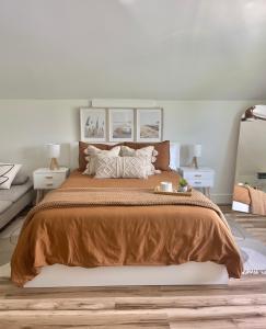 um quarto com uma cama grande e um cobertor castanho em Modern Coastal Getaway in Kilmarlic Golf Club em Powells Point