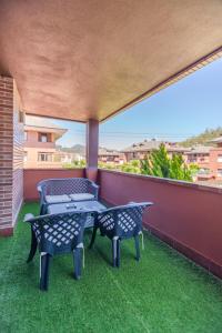 patio z 2 krzesłami i stołem na balkonie w obiekcie Amplio apartamento en Guriezo w mieście El Puente