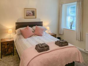 a bedroom with a bed with two bags on it at Milnhead Cottage in Amisfield Town