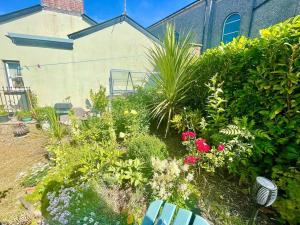 a garden with flowers and plants in front of a building at Cottage,Cinema Room,Log Burner in Blaenavon