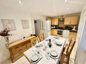 a kitchen with a table with plates and wine glasses at Cottage,Cinema Room,Log Burner in Blaenavon