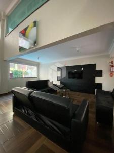 uma sala de estar com um sofá de couro preto em Bombinhas Summer Beach 252 em Bombas