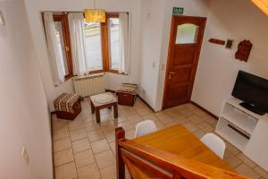 una pequeña sala de estar con mesa y TV en Cabaña 1 Comoda, Cálida y Confortable en Ushuaia