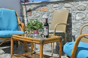 a table with a bottle of wine and glasses on it at Maria's House in Hydra