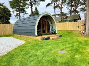 a small green dome house in a yard at Brora Pods in Brora