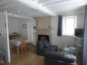 ein Wohnzimmer mit einem Sofa und einem Esstisch in der Unterkunft Gite LA CHARRETTERIE in Martragny