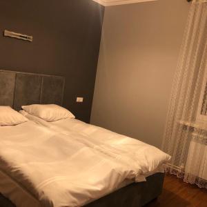 - une chambre avec un lit doté de draps blancs et une fenêtre dans l'établissement The Nest JERMUK, à Jermuk