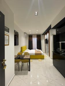 sypialnia z łóżkiem i stołem w obiekcie Sueño Apartments & Suites w Tiranie