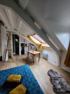 an attic room with a bed and a table at Les Z'amours in Honfleur