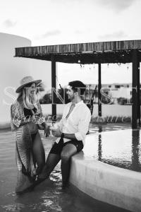 Ein Mann und eine Frau sitzen im Wasser in der Unterkunft Hunab Tulum in Tulum