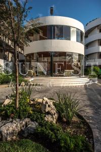 ein großes weißes Gebäude mit einem Baum davor in der Unterkunft Hunab Tulum in Tulum