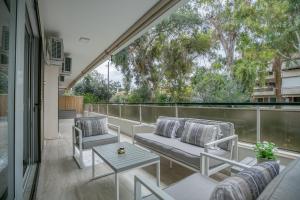 eine Terrasse mit 2 Stühlen und einem Tisch auf dem Balkon in der Unterkunft Elaia Luxury Selections Sapphire in Athen