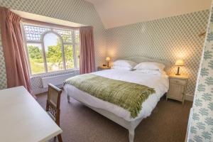 a bedroom with a large bed and a window at The Five Arrows Hotel in Waddesdon