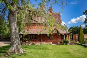 a red brick house with a tree in the yard at The Five Arrows Hotel in Waddesdon