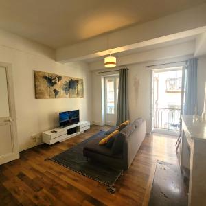 a living room with a couch and a television at Chez Odette in Grenoble