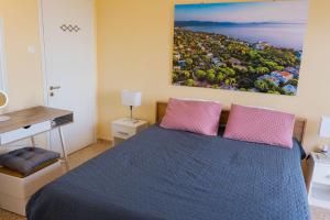 1 dormitorio con 1 cama azul y 2 almohadas rosas en Zoumperi Nea Makri 4-5 guest apt big balconies 5 min to beach, en Nea Makri