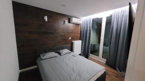 niewielka sypialnia z łóżkiem i oknem w obiekcie Apartament AGA Mogilska Tower w Krakowie