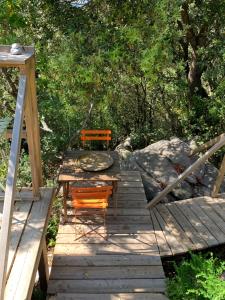 2 sillas y una mesa en una terraza de madera en Corsica Natura #2, en Coti-Chiavari