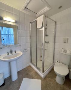 uma casa de banho com um chuveiro, um lavatório e um WC. em The Gateway Hotel em Londres