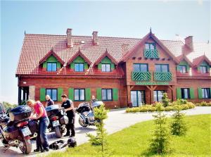 un grupo de personas en motocicleta frente a una casa en Mazurska Chata jezioro i aquapark 6 min centrum i promenada 12 min en Mikołajki