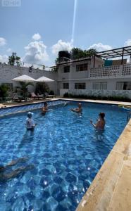 eine Gruppe von Personen, die in einem Pool sitzen in der Unterkunft Kalathea Casa in Tocaima