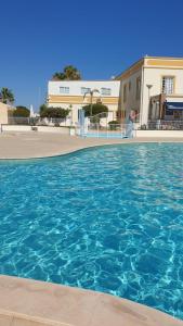 - une piscine d'eau bleue en face d'un bâtiment dans l'établissement Ponta Grande Villa 29, à Albufeira