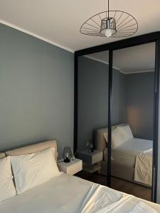 a bedroom with two beds and a large mirror at Ivi's apartment sea view in Vlorë