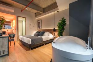 ein Bad mit Badewanne und ein Bett in einem Zimmer in der Unterkunft HASHTAG 98 HOTEL in Medellín