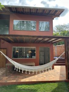 a house with a hammock in front of it at Lençóis em cantos in Lençóis