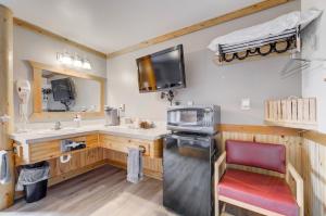 eine Küche mit einer Spüle und einer Theke mit einem Stuhl in der Unterkunft Livingston Inn in Livingston