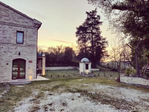 ein Backsteingebäude mit einem kleinen Observatorium in einem Hof in der Unterkunft L' Antico Pozzo Country House in Monsampietro Morico