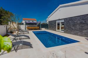 a swimming pool in the backyard of a house at Villa Tomic in Vir