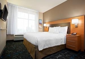 um quarto de hotel com uma cama grande e uma janela em TownePlace Suites by Marriott Carlsbad em Carlsbad