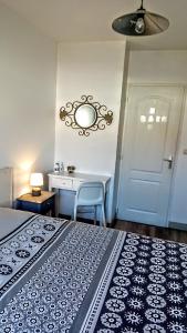 een slaapkamer met een bed, een tafel en een spiegel bij Les Bois Flottés en Ré in Sainte-Marie-de-Ré