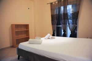 a bedroom with a bed with two towels on it at SAN FLORAN in Áyios Flóros